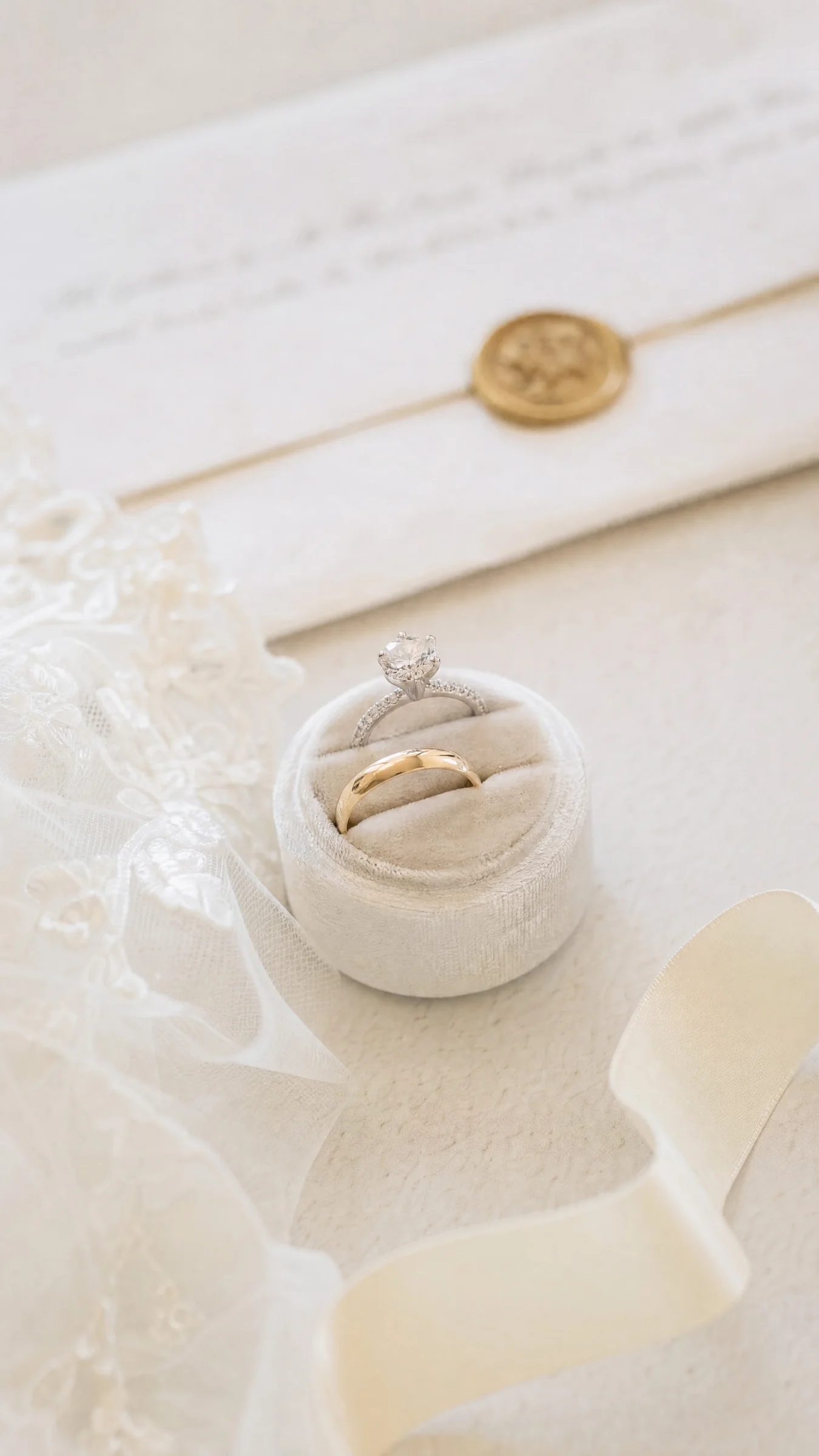 Alliances et bague de fiançailles dans un écrin de velours, capturées par un photographe de mariage à Romans