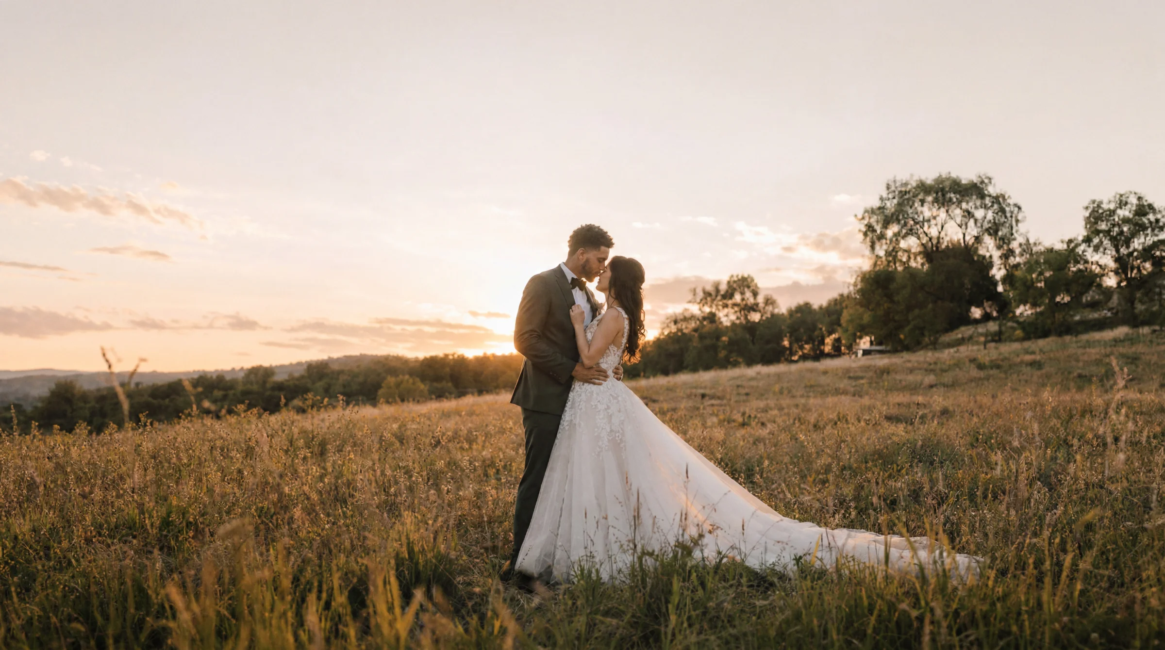 Couple de mariés s'embrassant dans un champ ensoleillé à Montélimar, reportage mariage au coucher du soleil