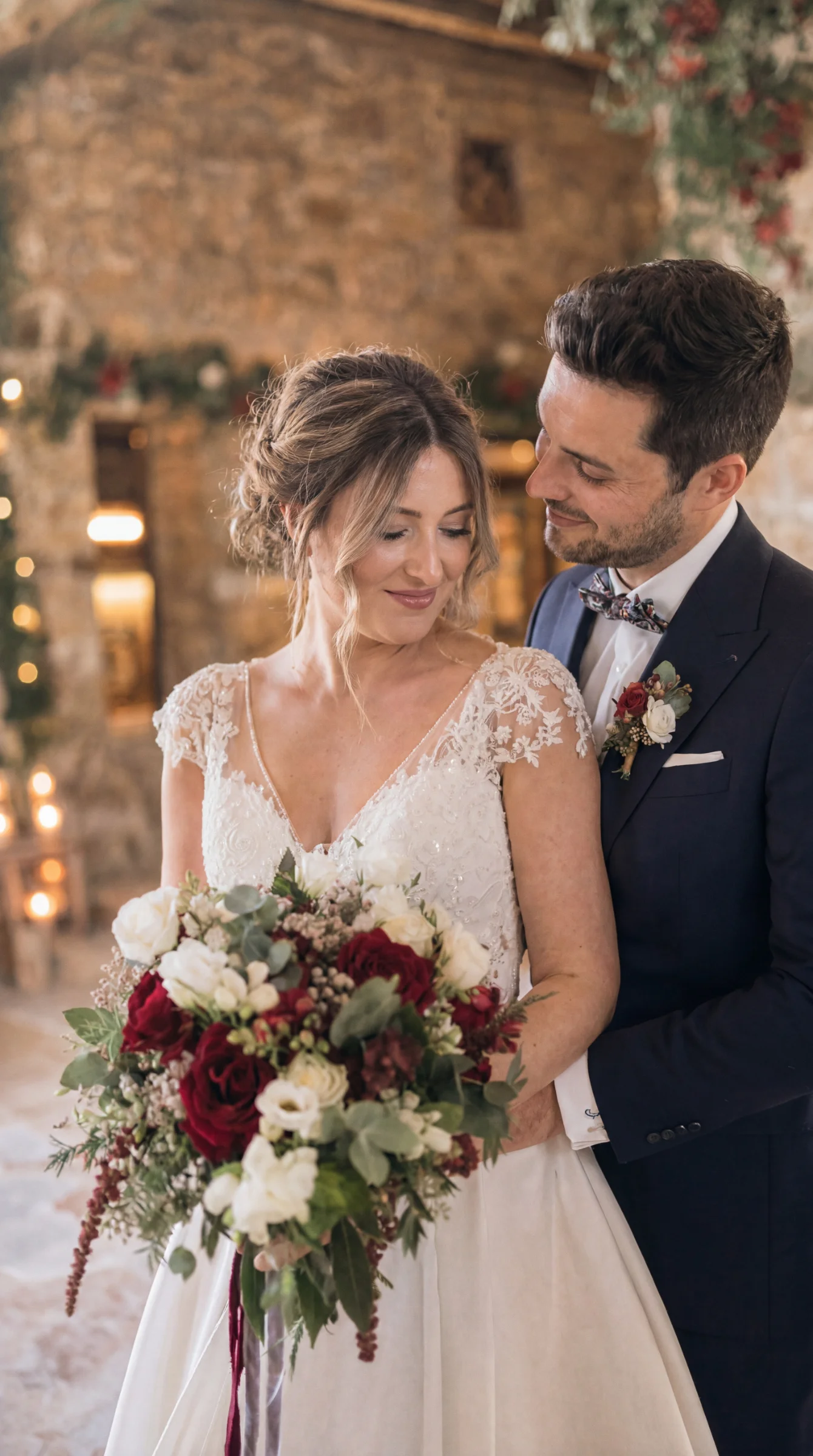 Couple de mariés élégants, la mariée tenant un bouquet rouge et blanc, lors d'un reportage mariage à Montélimar