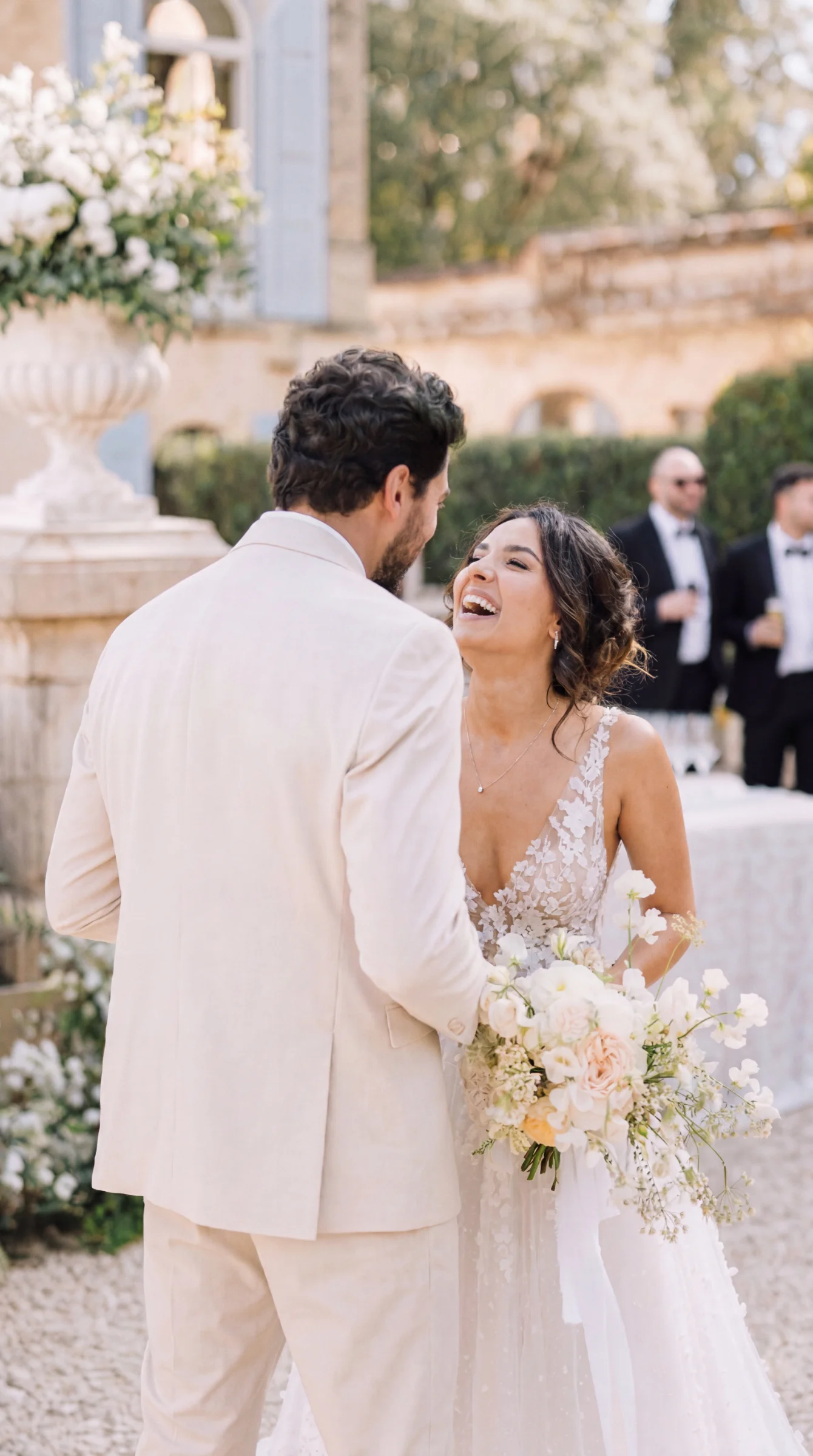 Mariés riant joyeusement lors d'un reportage mariage à Romans, la mariée tenant un bouquet de fleurs claires